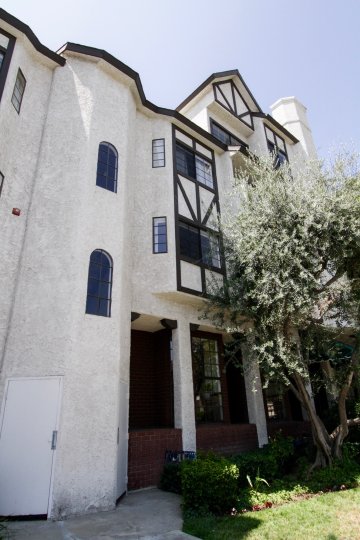 A four story building with a tree in front in Hampton Court community in Orange Californa.