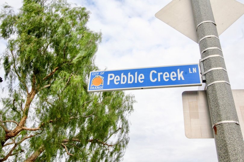 A street sign for Pebble Creek in Riverbend on a stop sign in a cloudy day