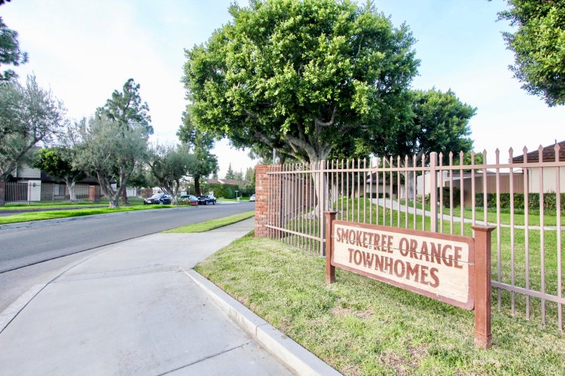 A beautiful day in the Smoketree Orange Townhomes with a signage and trees.