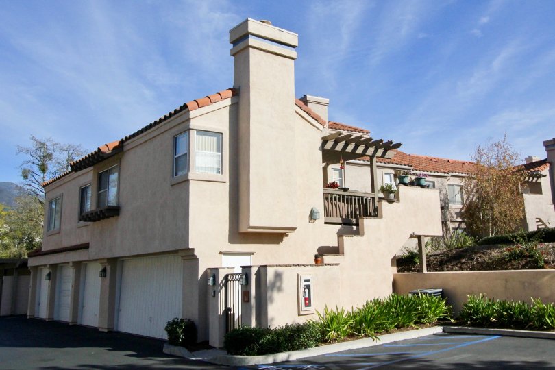A apartment complex with white walls and garages in Brisa del Lago I community in Rancho Santa Margarita, California.
