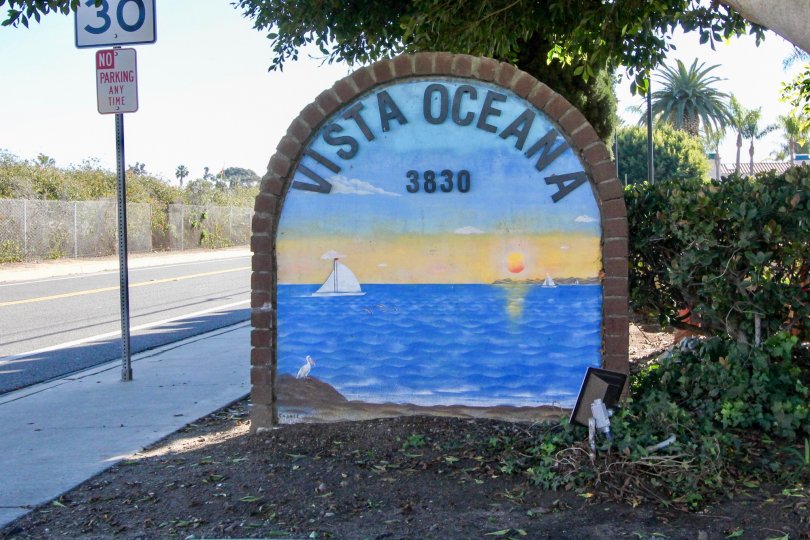 A sign and address titled Vista Oceana 3830 with a sailboat on the water mural backdrop