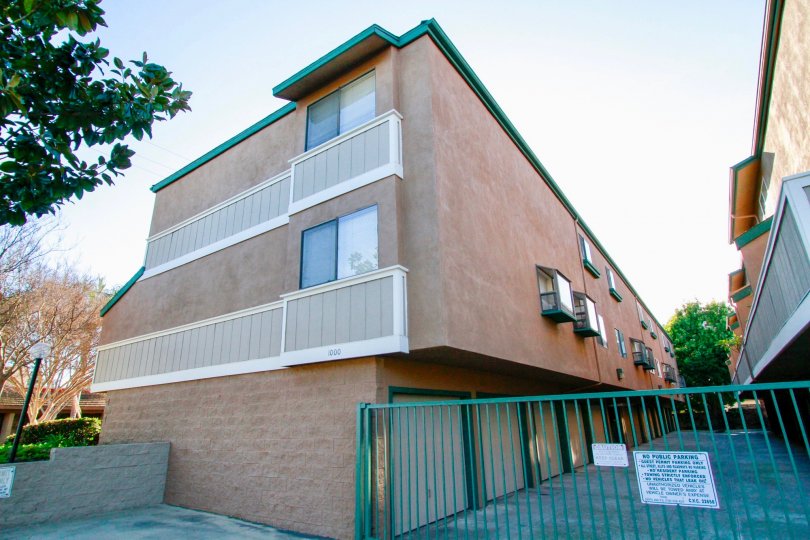 Sunny day in Emerald Terrace with a view of the back side of a housing unit with garage access.