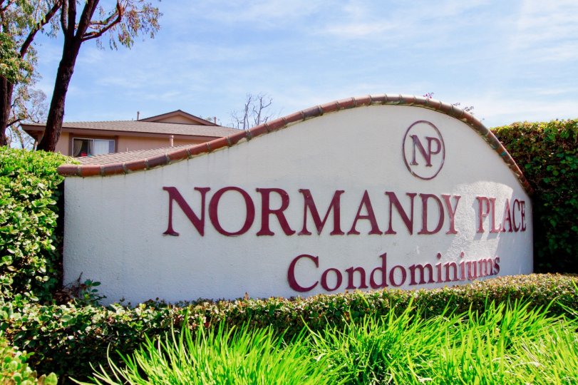 The entrance board to Normandy place community with green grass around