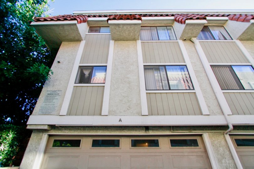 A big beautiful white and grey color apartment in the North Broadway Townhomes with glass windows and big trees.