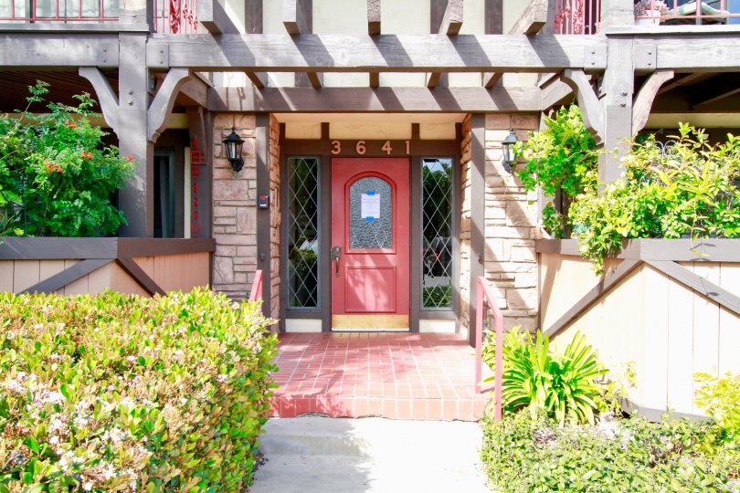A red doors sits in the shade on a sunny day at St Albans condos