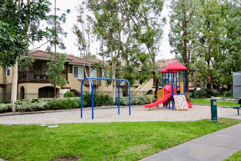 A red, blue and yellow playset sits in a park at the Corte Villa homes