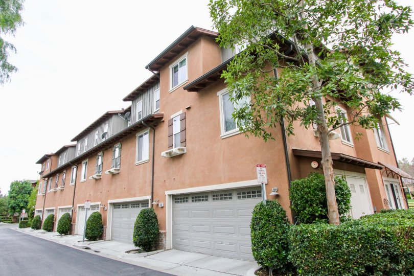 Three-storey residences with grayish and orangish paints in the Tustin Field community.