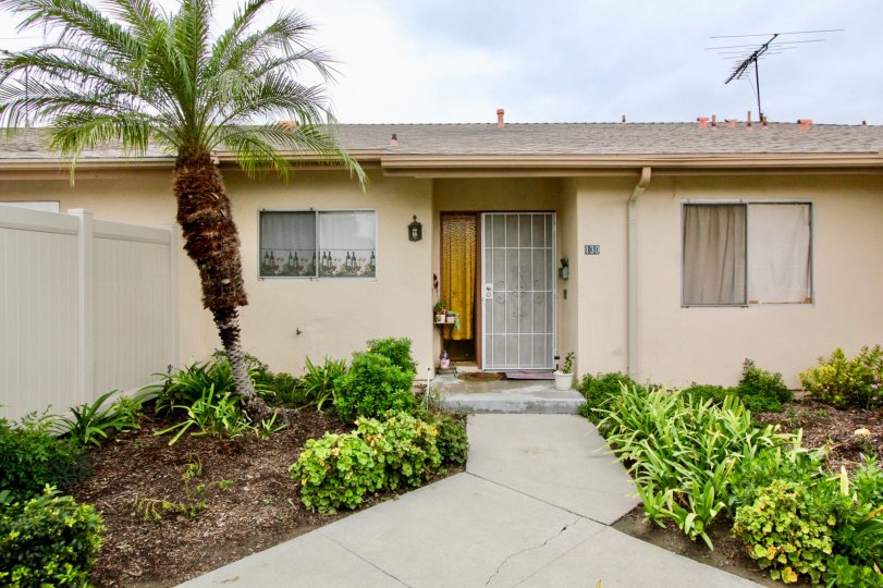 A one story home at Tustin Park Villas with a palm tree, satellite for tv and private side yard
