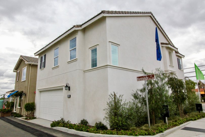 A two story home in the Provence community with a garage and flag.