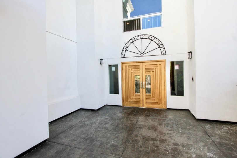 THE BUILDING IN THE CORTEZ BUILDING WITH THE ARC ENTRANCE, WOODEN DOOR, BALCONI