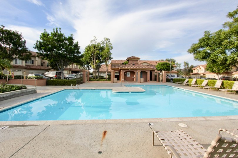 THE HOUSE IN THE FAIRWAY VILLAGE WITH THE SWIMMINGPOOL, TABLES, CAR PARKING, TREES
