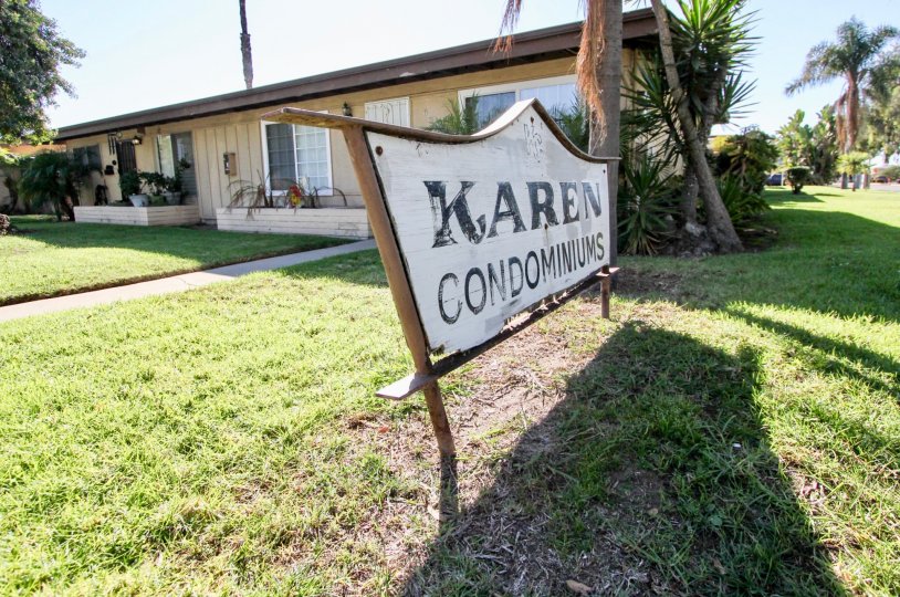 A white and wooden sign announces to visitors they have arrived at the Karen Condominums