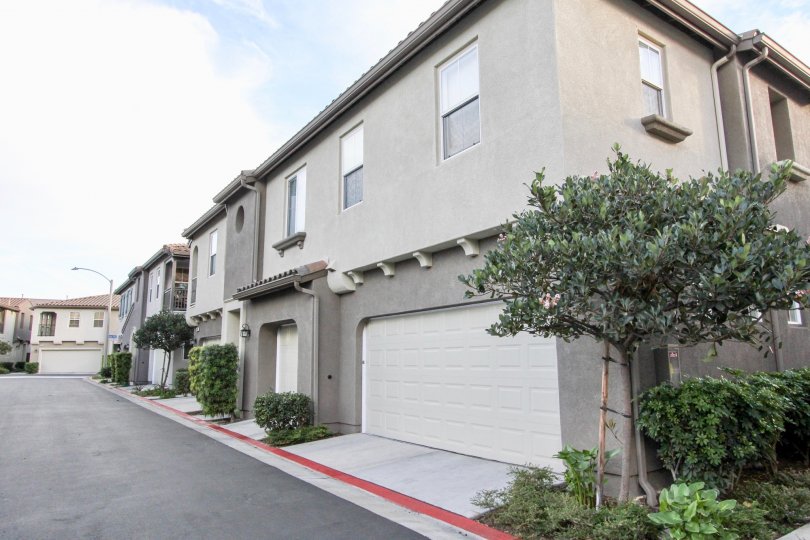 A clear road in front to the garages and front doors of the tidy and peaceful townhomes of Summer Hill in Chula Vista, California.