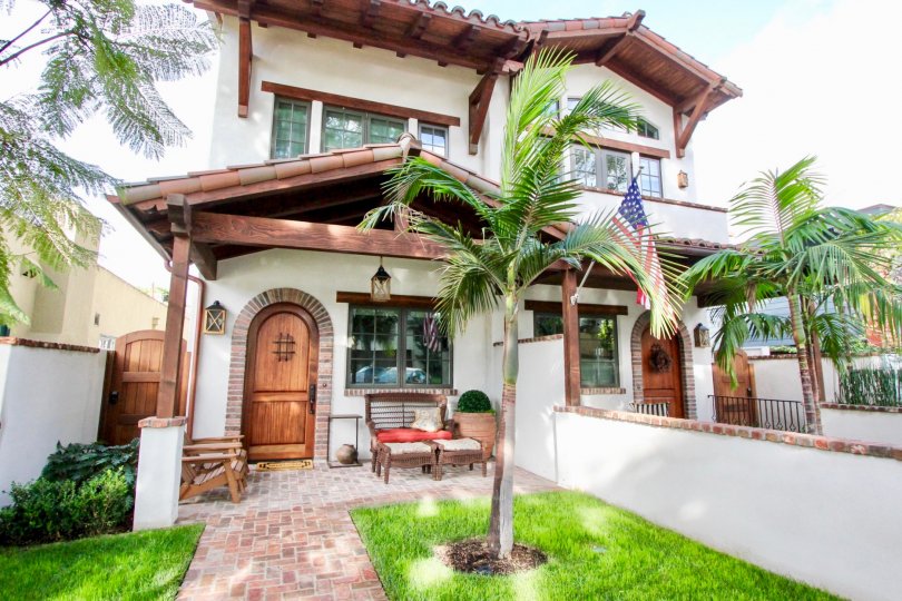 An intricate style home with palm trees in the front in the community Villas.