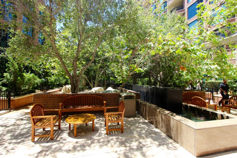 A sunny day at Cityfront Terrace in Downtown San Diego with outdoor seating, beautiful foliage and water features.