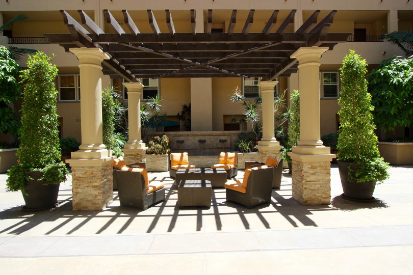 Orange and brown patio furniture sits under a pergola at Citywalk condos