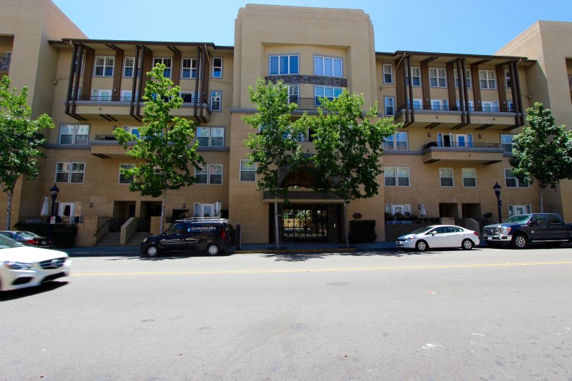 A sunny day in Downtown San Diego California with an apartment building with cars parked out front.
