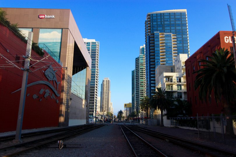 Train tracks below tall buildings at DOMA inside Towntown San Diego CA