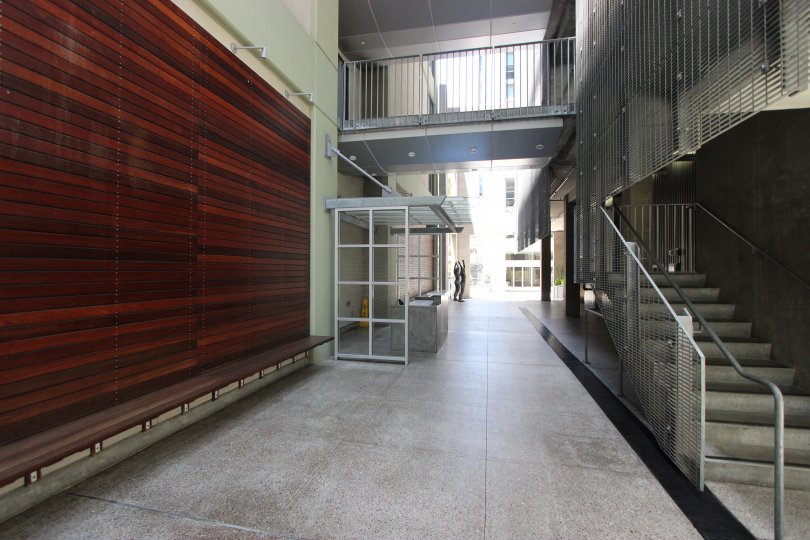 A wood paneled centerpiece wall sits across from a stairwell at Icon condos