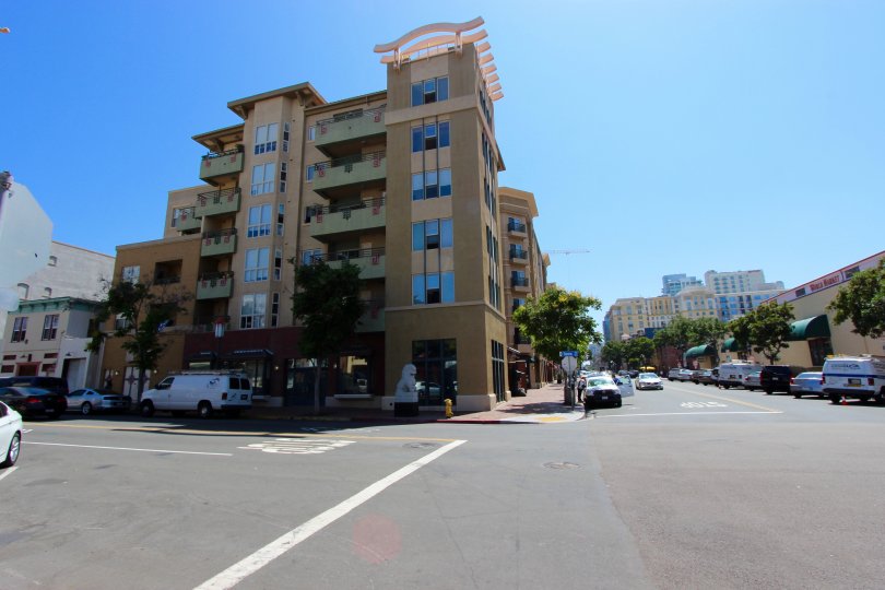 A sunny and cheerful day at the Pacific Terrace with a panoramic view of the classy and contemporary building and the tree-streets with the shops and parked cars