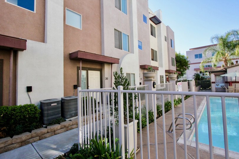 THE BUILDING IN THE URBANA AT CITRACADO VILLAGE WITH THE SWIMMING POOL, TABLE, UMBRELLA