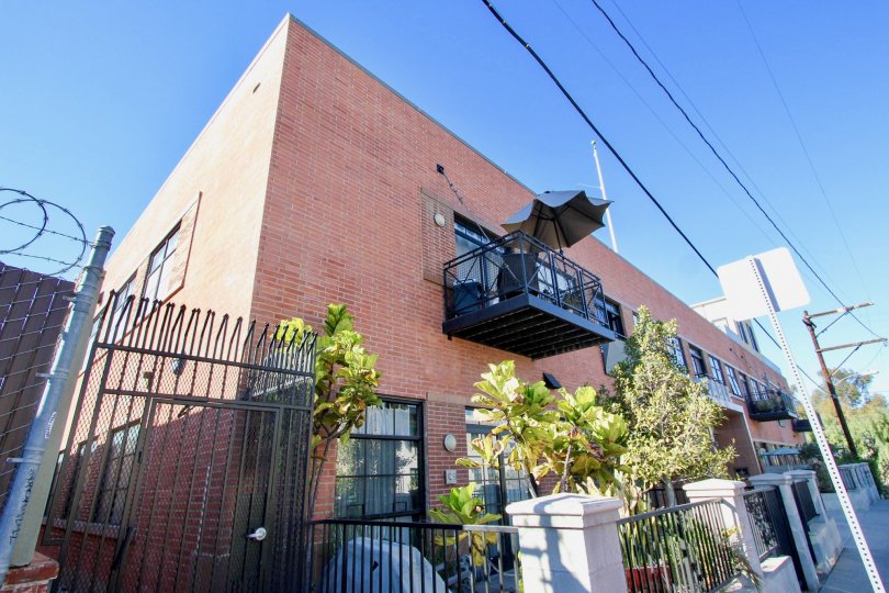 A sunny day in the area of Cable Building Lofts, outside, balcony, fence, barbed wire, umbrella