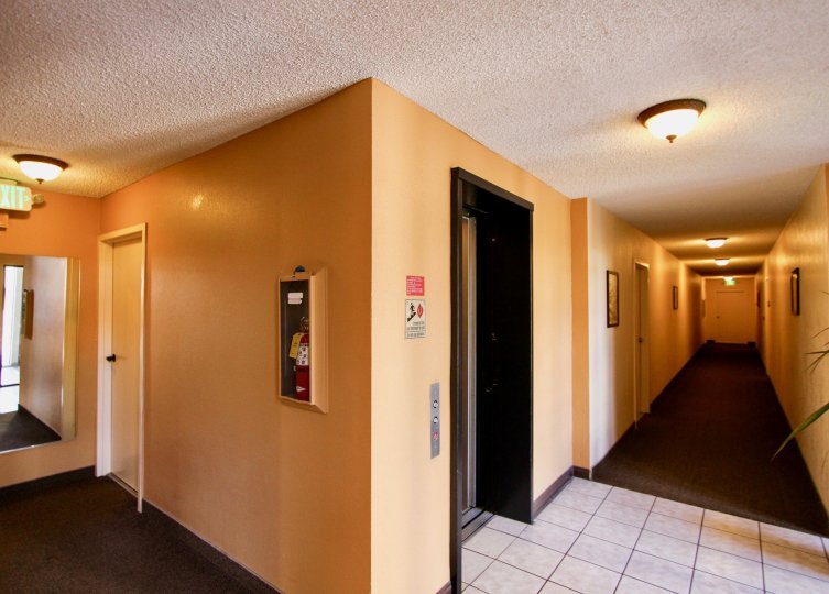 A corridor inside a building in the Mission Crest Gardens with lights.