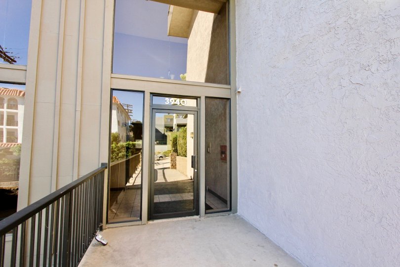 A sunny day in the area of Mission Crest Gardens, fence, palm tree, bush, door, reflection