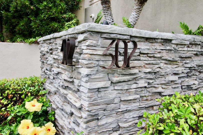 Large gray stone wall with address outside of 302 Prospect in La Jolla CA