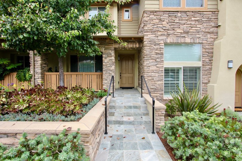 A walkway to the front door of a stone residence in Paseo La Jolla, California