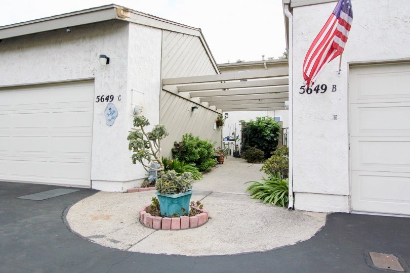Quaint space between double car garages with cute gardens and pergola overhead in La Mesa