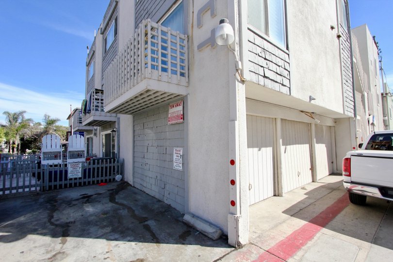 White apartment building with garages and available parking