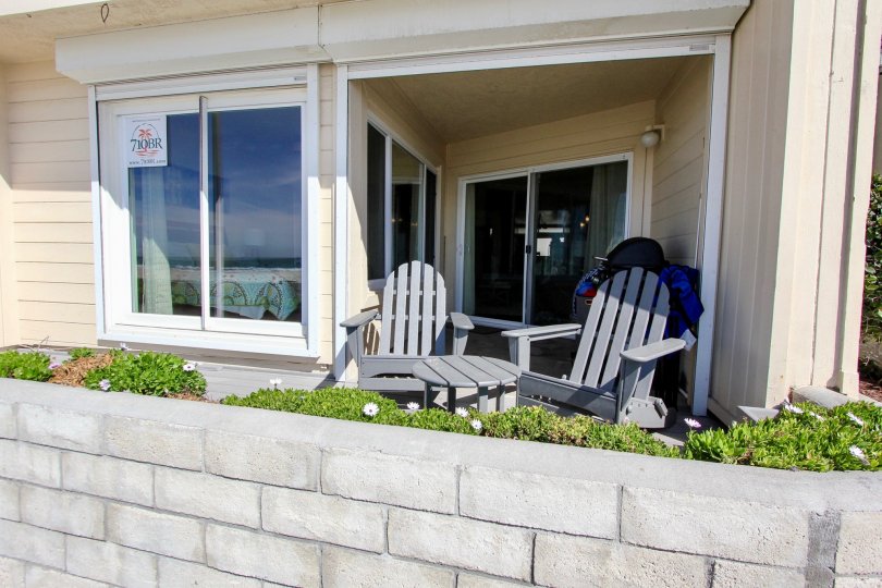 The outdoor patio with lawn chairs and table behind a retaining wall at the Top of the Beach apartments.