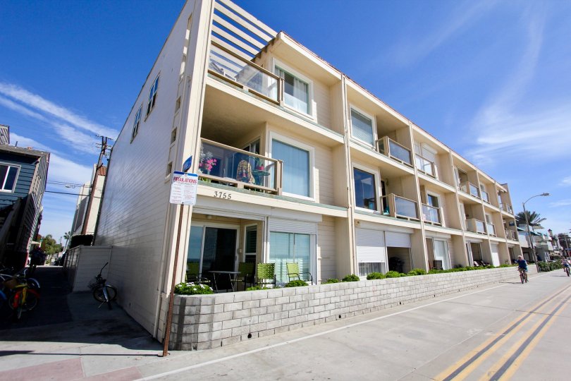 A sunny day at top of the beach showing the road and the balcony apartments