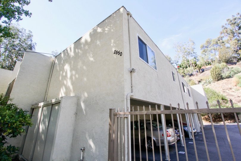 A sunny day in the area of La Casa Reynard, gate, cars, parking lot, condo
