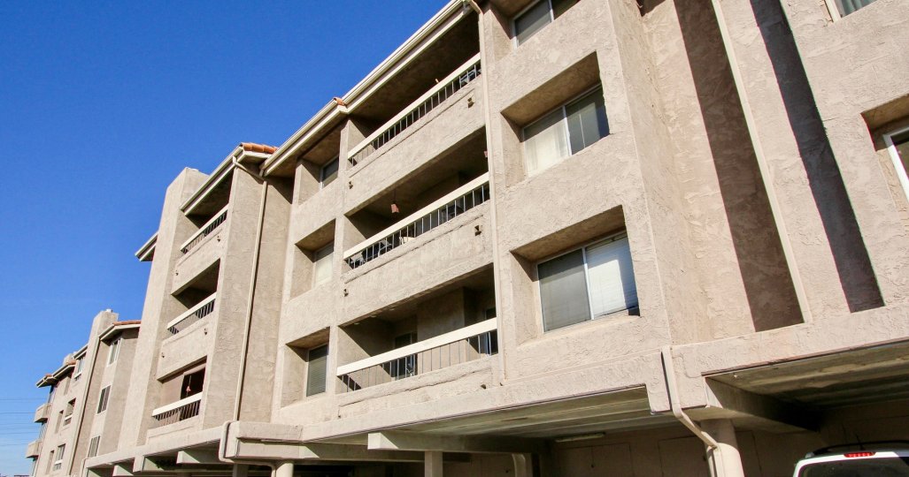 A white Suv sits in the shade under an residential building at the Mission Ridge condos.