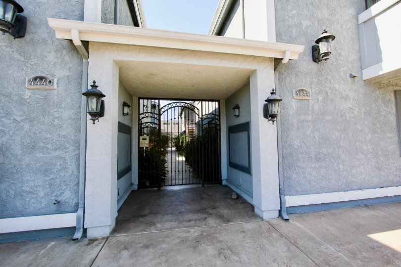 Entrance of complex #4440 with black gate and two lantern lamps.