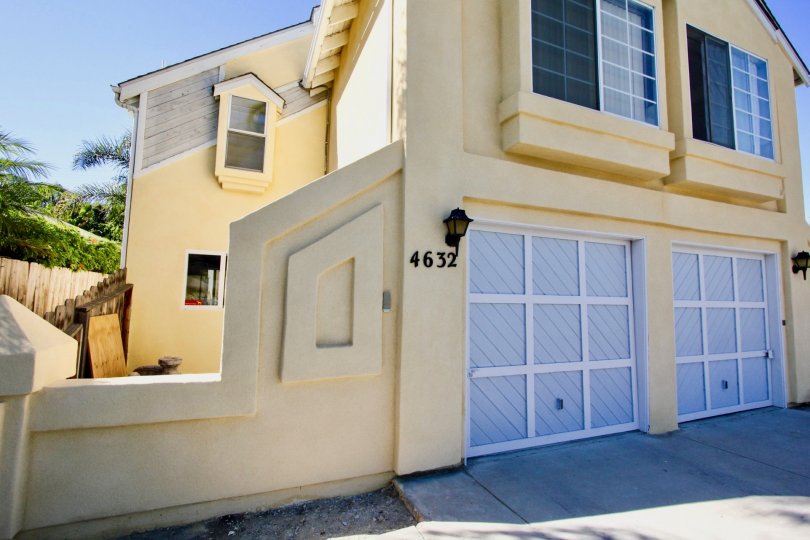 A beautiful yellow home with two garage doors located in the Normal House II Community.