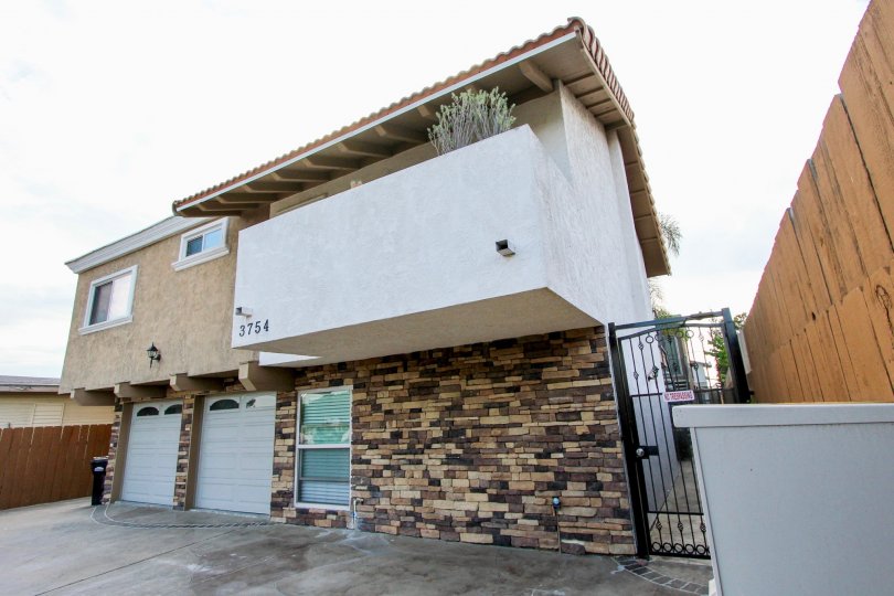 Two story residential building with security gate and two car garages at Estelle in North Park California