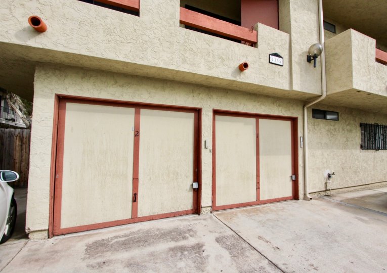 The exterior of Villa De 33rd shows 2 garage doors and two parking spaces below balconies
