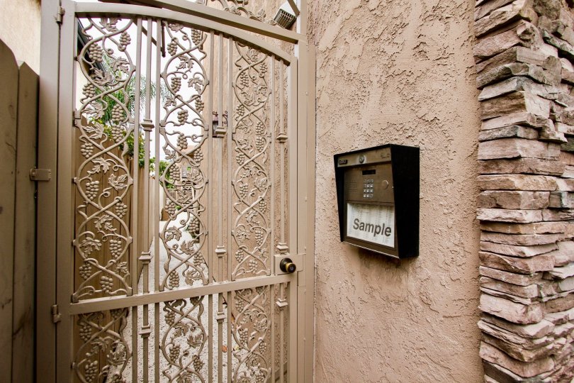 Metal intercom at pink gate inside Villas on Idaho at North Park CA