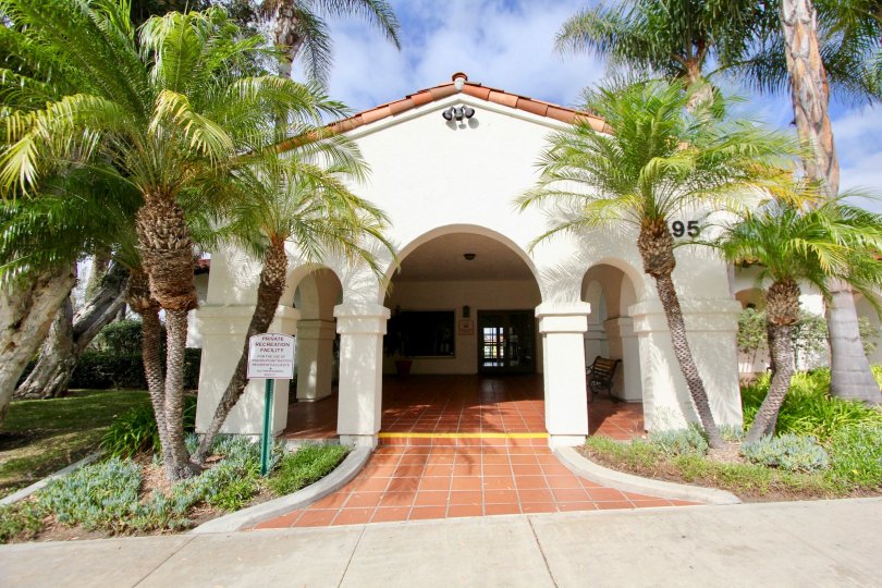 Palm trees by an archway leading to the entrance of Mission Point Townhomes in Oceanside, CA