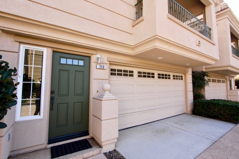 Green front door, balcony and gargage door of 713 Sea Breeze Beach Cottages in Oceanside, CA.