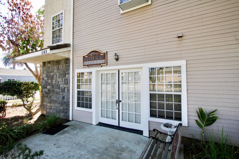 Two white and glass doors in front of Silver Surf Gardens at Oceanside CA