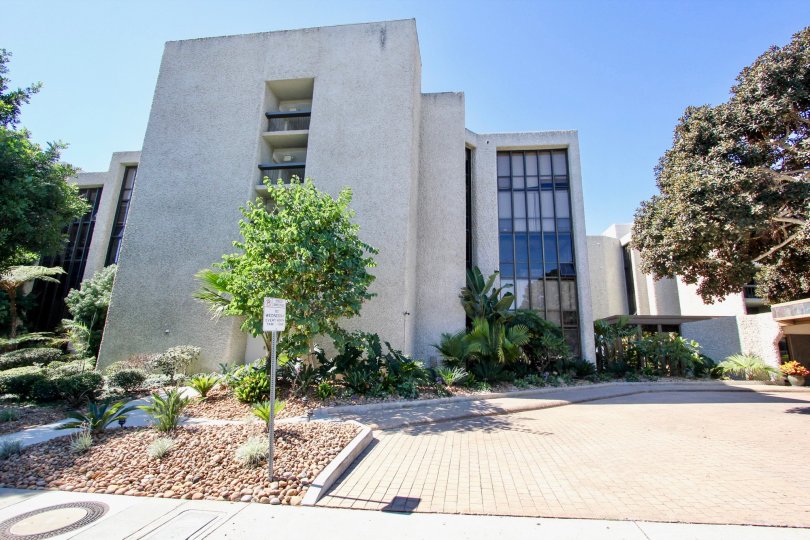 Side to the pathway of apartment in Bay Scene has board with meadows and trees