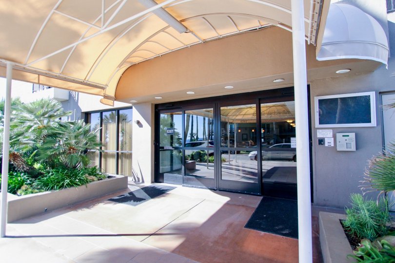 covered entryway leading to glass automatic door and security entrance