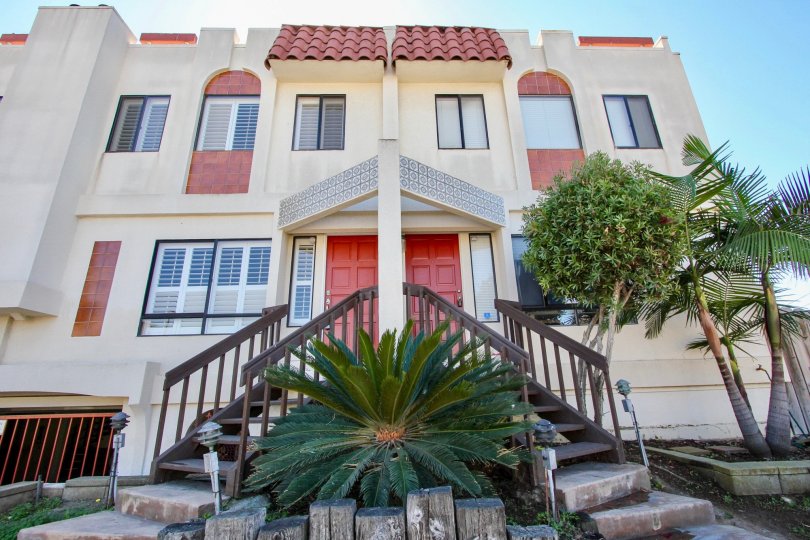 A sunny day in the area of Riviera Cove, outside, stairs, condos, palm trees, red door, windows