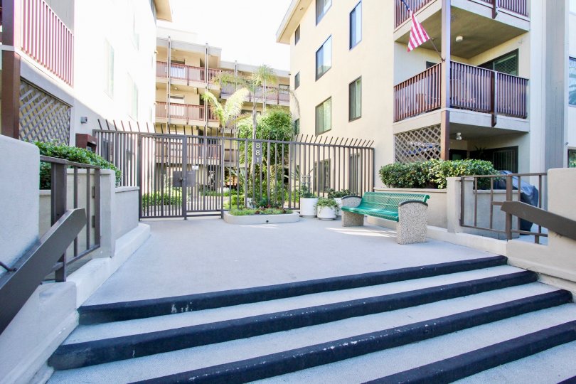 An entryway with a gray gate and a green bench in the Turramurra Condominiums.