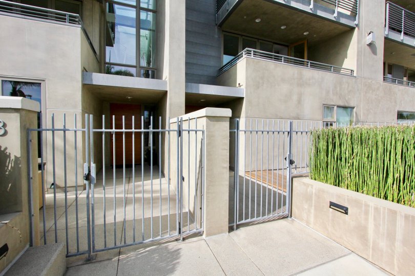 This is the front of a community building built with concrete, and showing the gated fence and balconies in the picture.