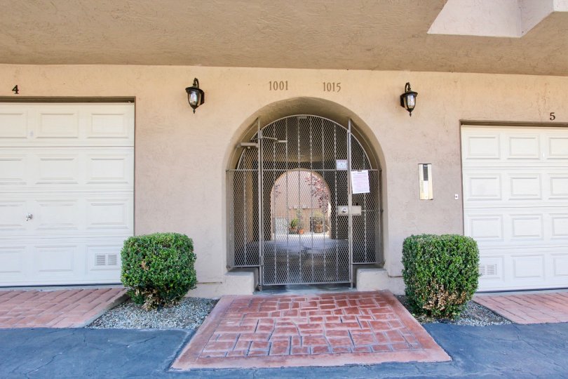 An arched entrance with a gate in the Avocado Gardens neighborhood.